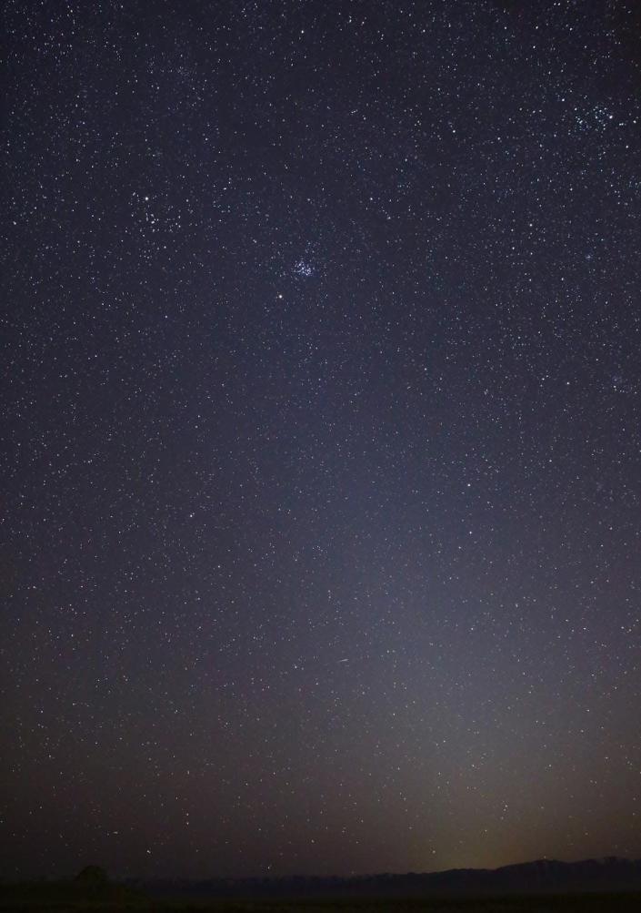 zodiacal light nighttime starry sky with yellow glow on the horizon