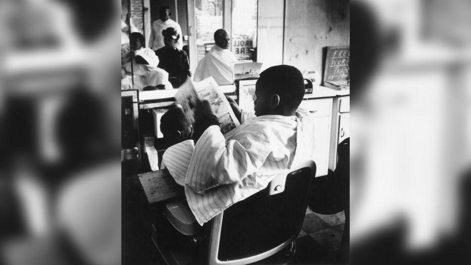 A young barbershop customer is seen in New York City's Harlem neighborhood, February 1956. - Mario De Biasi/Mondadori/Getty Images