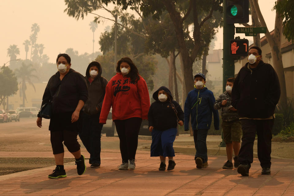 <p>A family walks through the streets of Ventura, California, on December 6. </p>