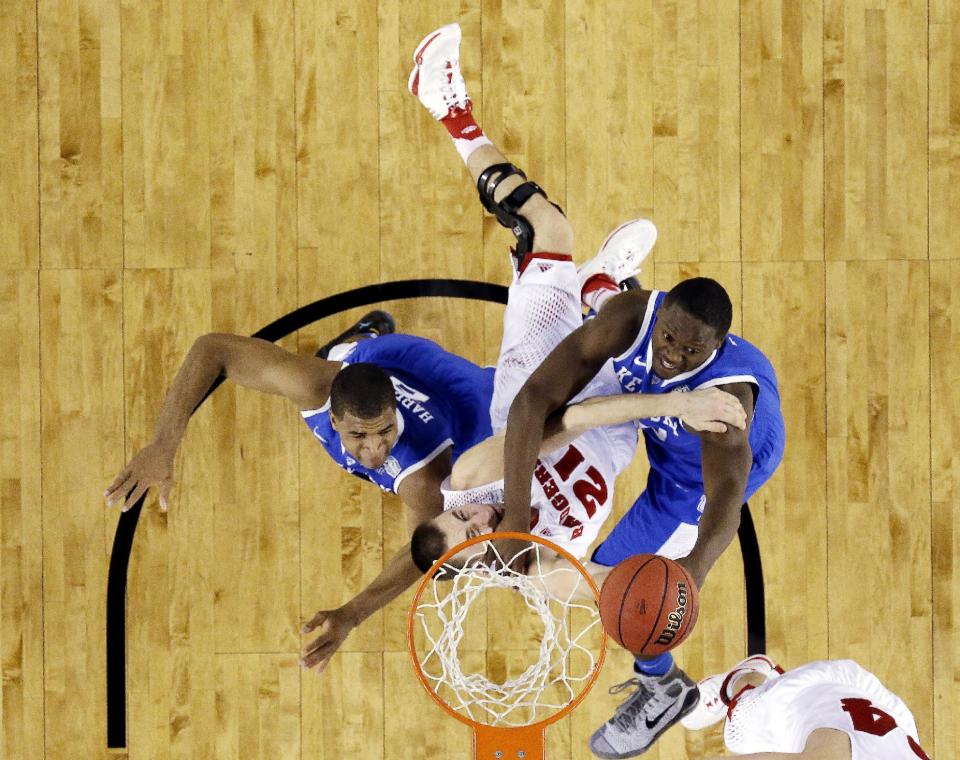CORRECTS WISCONSIN PLAYER TO JOSH GASSER, INSTEAD OF TRAEVON JACKSON - Wisconsin guard Josh Gasser is caught between Kentucky guard Aaron Harrison (2) and forward Julius Randle (30) during the first half of the NCAA Final Four tournament college basketball semifinal game Saturday, April 5, 2014, in Arlington, Texas. (AP Photo/David J. Phillip)