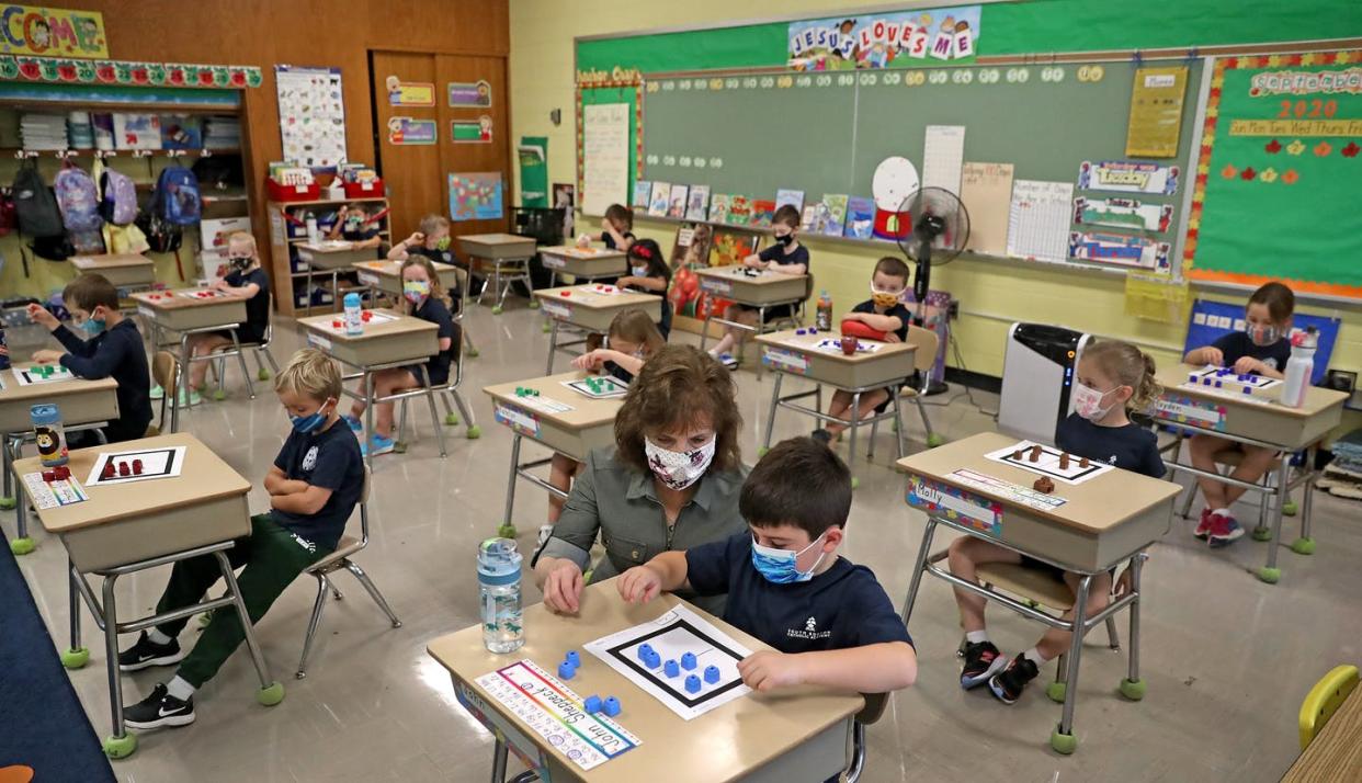 <span class="caption">Jean McCarthy helps a first-grade student at South Boston Catholic Academy on Sept. 10, 2020.</span> <span class="attribution"><a class="link " href="https://www.gettyimages.com/detail/news-photo/ms-jean-mccarthy-helps-a-first-grade-student-at-south-news-photo/1228455315?adppopup=true" rel="nofollow noopener" target="_blank" data-ylk="slk:David L. Ryan/The Boston Globe via Getty Images;elm:context_link;itc:0;sec:content-canvas">David L. Ryan/The Boston Globe via Getty Images</a></span>