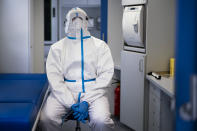 A volunteer of German Red Cross DRK wears protective gear as he waits in a mobile coronavirus test station for travellers from foreign countries, at the central bus terminal in Berlin, Germany, Tuesday, Aug. 4, 2020. (AP Photo/Markus Schreiber)