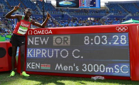 Conseslus Kipruto of Kenya celebrates breaking the olympic record and winning gold. REUTERS/Kai Pfaffenbach