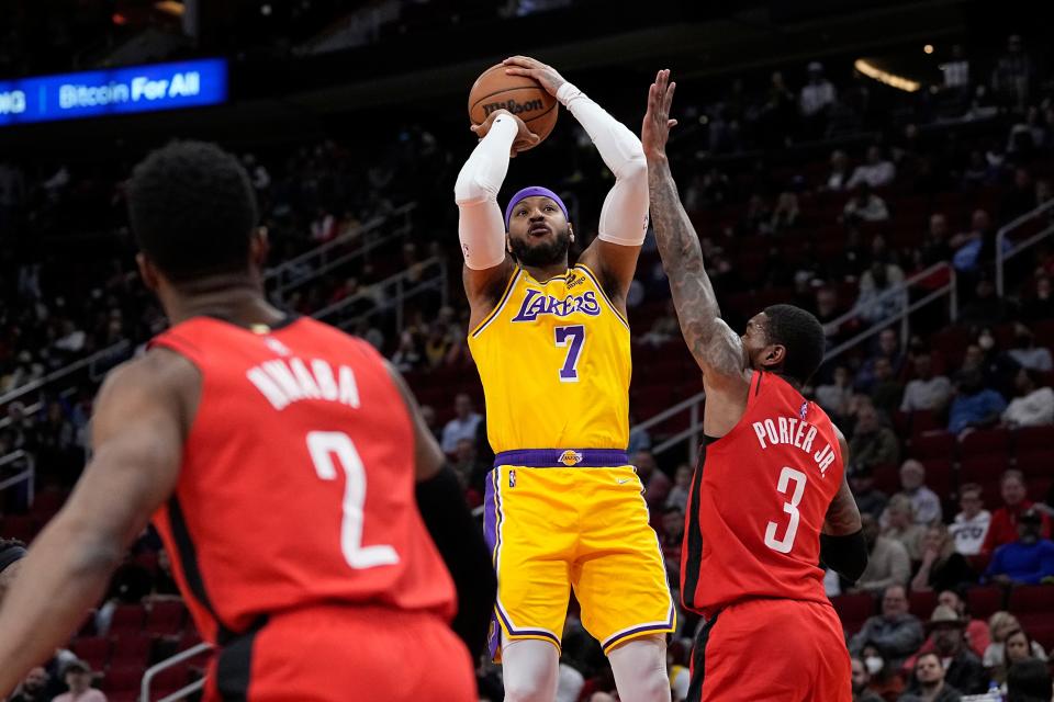 Los Angeles Lakers' Carmelo Anthony (7) shoots as Houston Rockets' Kevin Porter Jr. (3) defends during the first half of an NBA basketball game Wednesday, March 9, 2022, in Houston. (AP Photo/David J. Phillip)