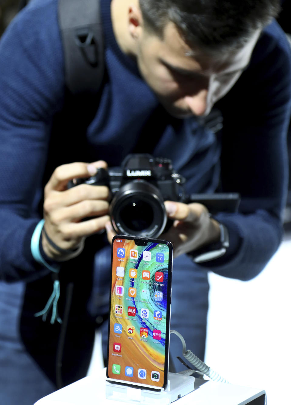 A man takes a picture of the new 'Huawei Mate 30' of China's smartphone manufacturer Huawei during an event in Munich, Germany, Thursday, Sept. 19, 2019. (AP Photo/Matthias Schrader)