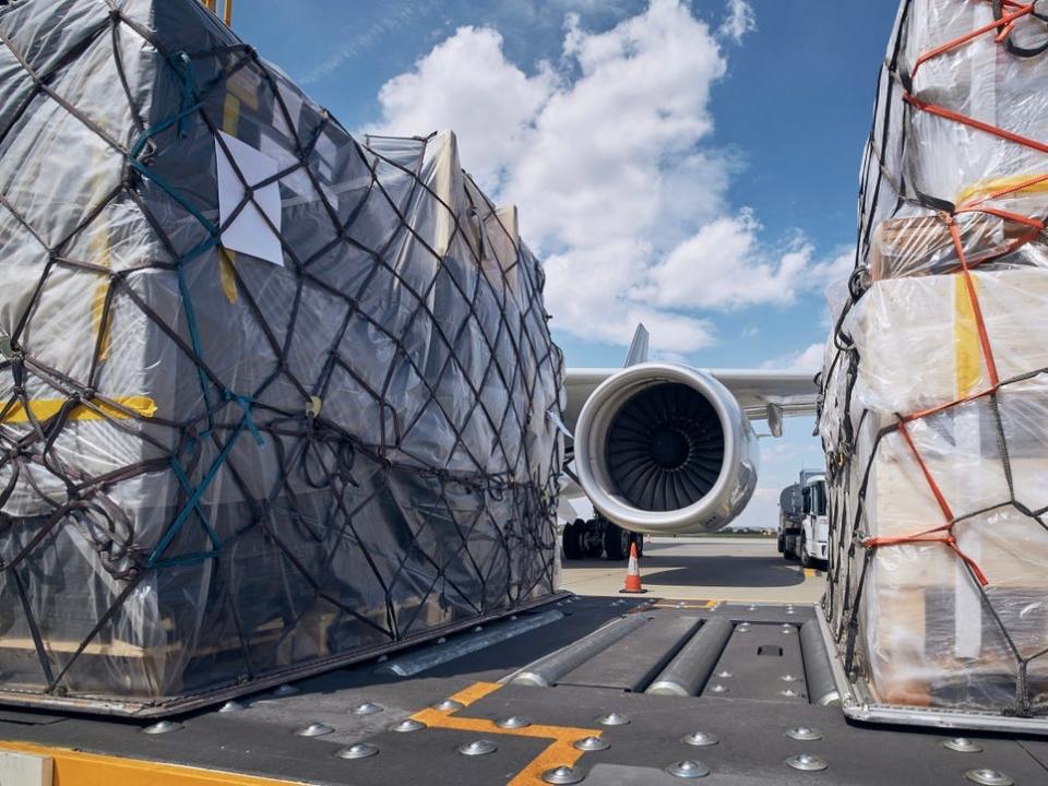 Preparation Before Flight. Loading Of Cargo Containers Against Jet Engine Of Freight Airplane