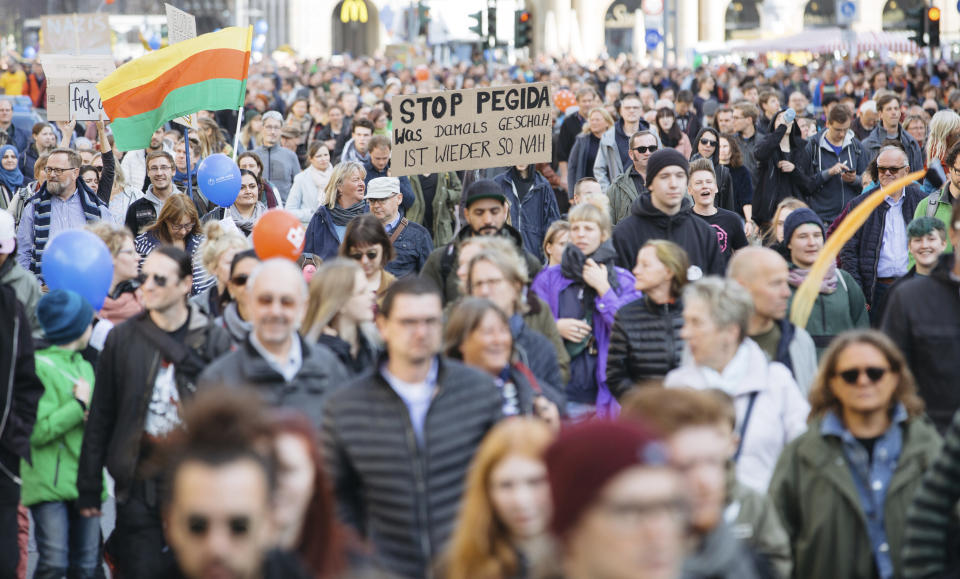 People attend a demonstration called "heart instead of hounding" to protest against a far right PEGIDA demonstration in Dresden, eastern Germany, Sunday, Oct.21, 2018. (Oliver Killig/dpa via AP)