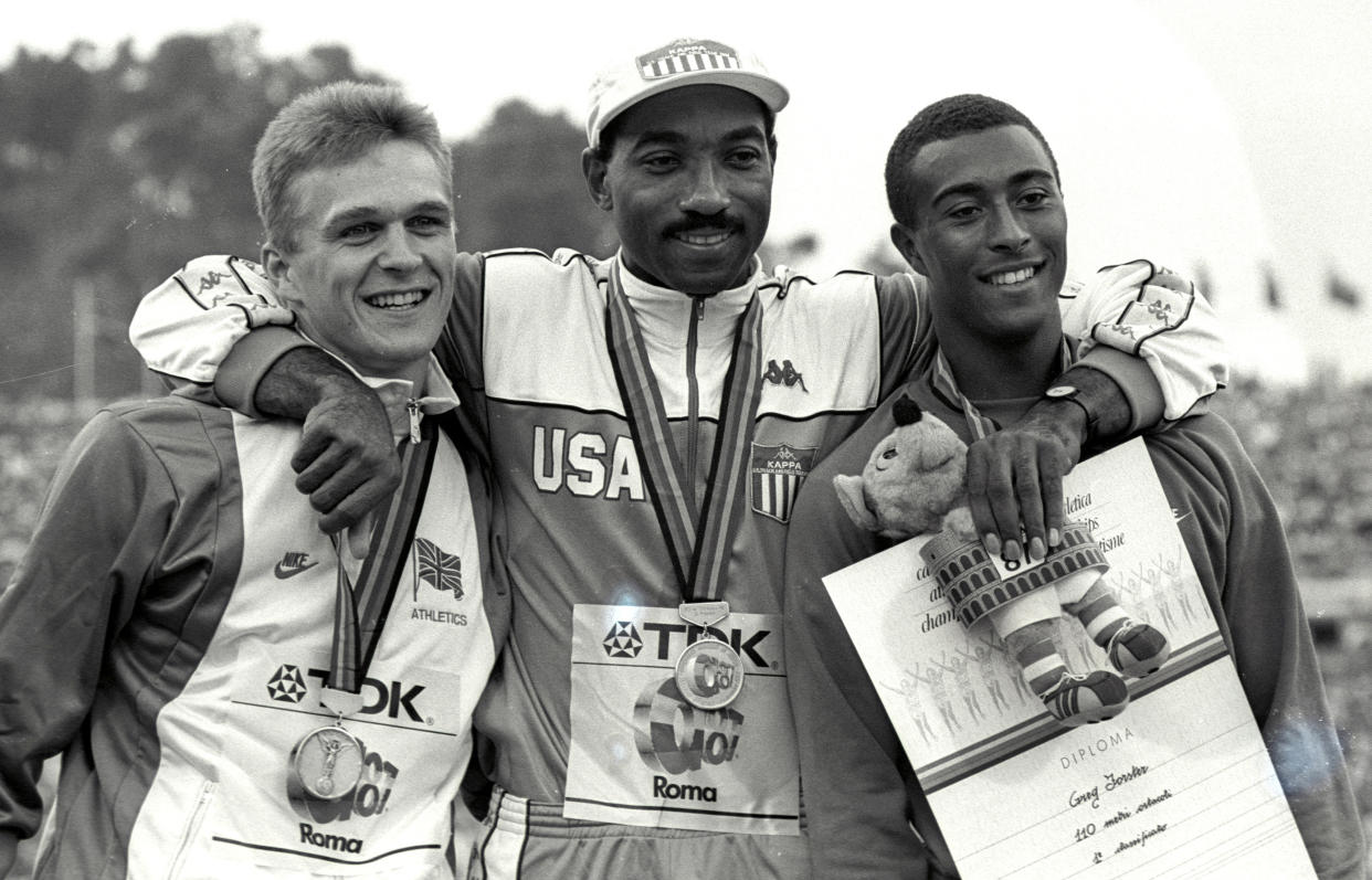 MEDALLISTS IN 110M HURDLES EVENT FOSTER OF THE USA, RIDGETON AND JACKSON OF BRITAIN POSES WITH MEDALS AT WORLD ATHLETICS CHAMPIONSHIPS IN ROME.  Gold medal winner Greg Foster of the US hugs his co-competitors, silver medal winner Jon Ridgeton (L) and bronze medal winner Colin Jackson both of Great Britain September 3, 1987 after receiving their medals at the World Athletics Championships in Rome. SCANNED FROM NEGATIVE REUTERS/Nick Didlick