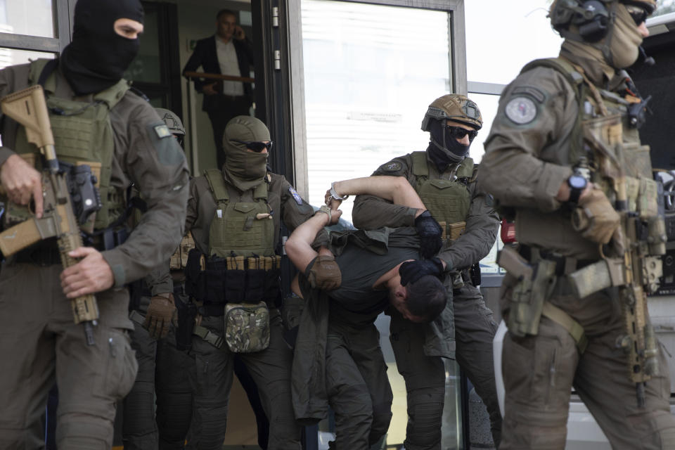 Kosovo police members of Special Intervention Unit escort one of the arrested Serb gunmen out of the court after the Kosovo shootout in capital Pristina, on Tuesday, Sept. 26, 2023. (AP Photo/Visar Kryeziu)