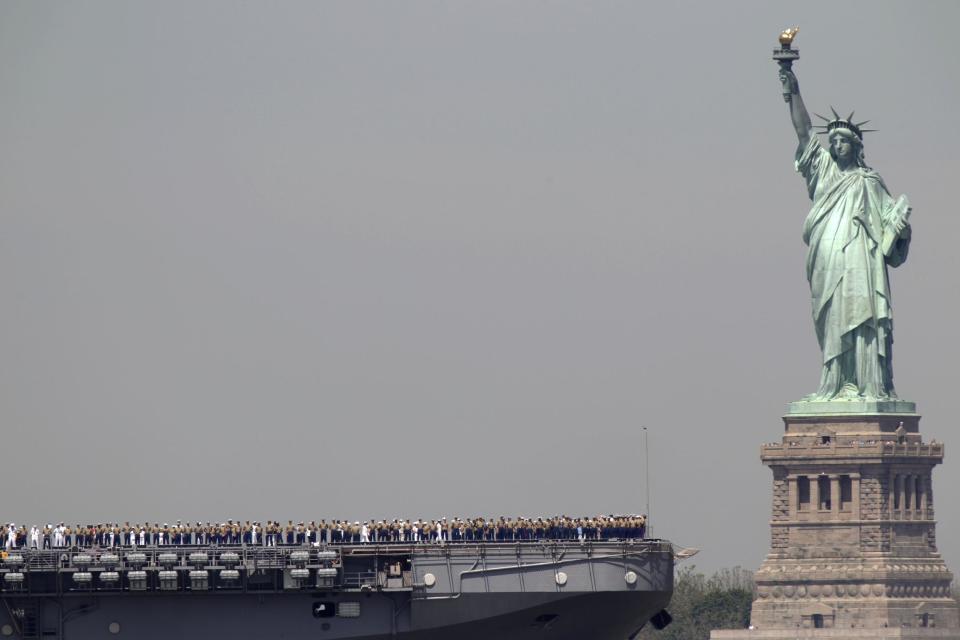 FILE - In this May 25, 2011 file photo, sailors stand on deck of the USS Iwo Jima as it passes the Statue of Liberty during Fleet Week in New York. The Statue of Liberty, which has been closed to visitors since Superstorm Sandy, is scheduled to reopen for tours July Fourth, when Statue Cruises resumes departures for Liberty Island from Lower Manhattan. (AP Photo/Seth Wenig, file)