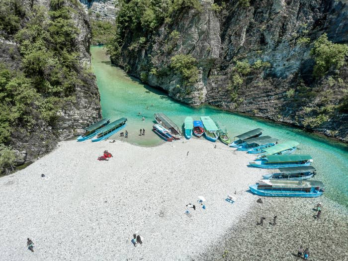 People and boats on a beach in  Shkodër, Albania.