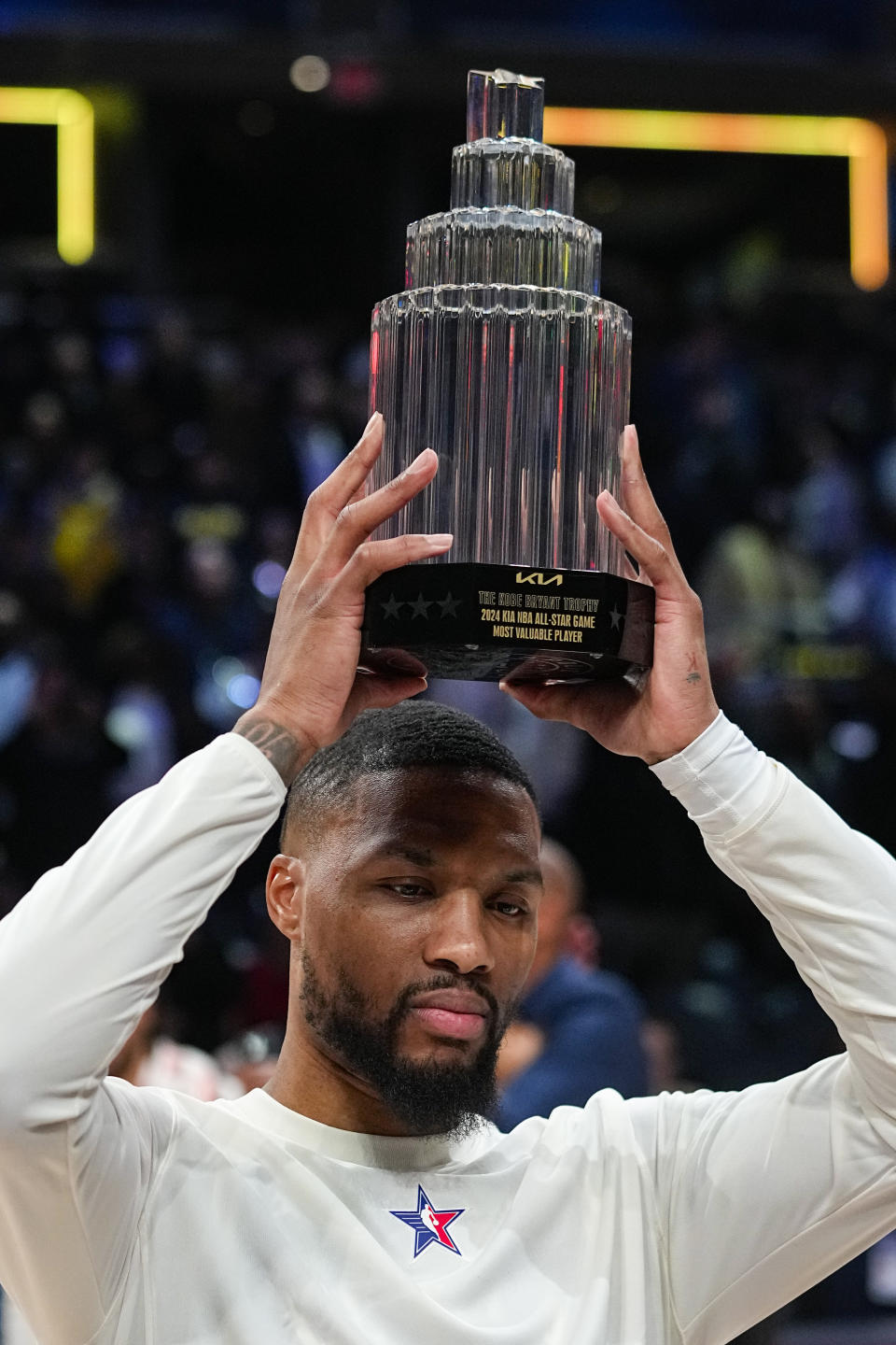 Milwaukee Bucks guard Damian Lillard (0) lifts the MVP trophy after the East defeated the West 211-186 in the NBA All-Star basketball game in Indianapolis, Sunday, Feb. 18, 2024. (AP Photo/Darron Cummings)
