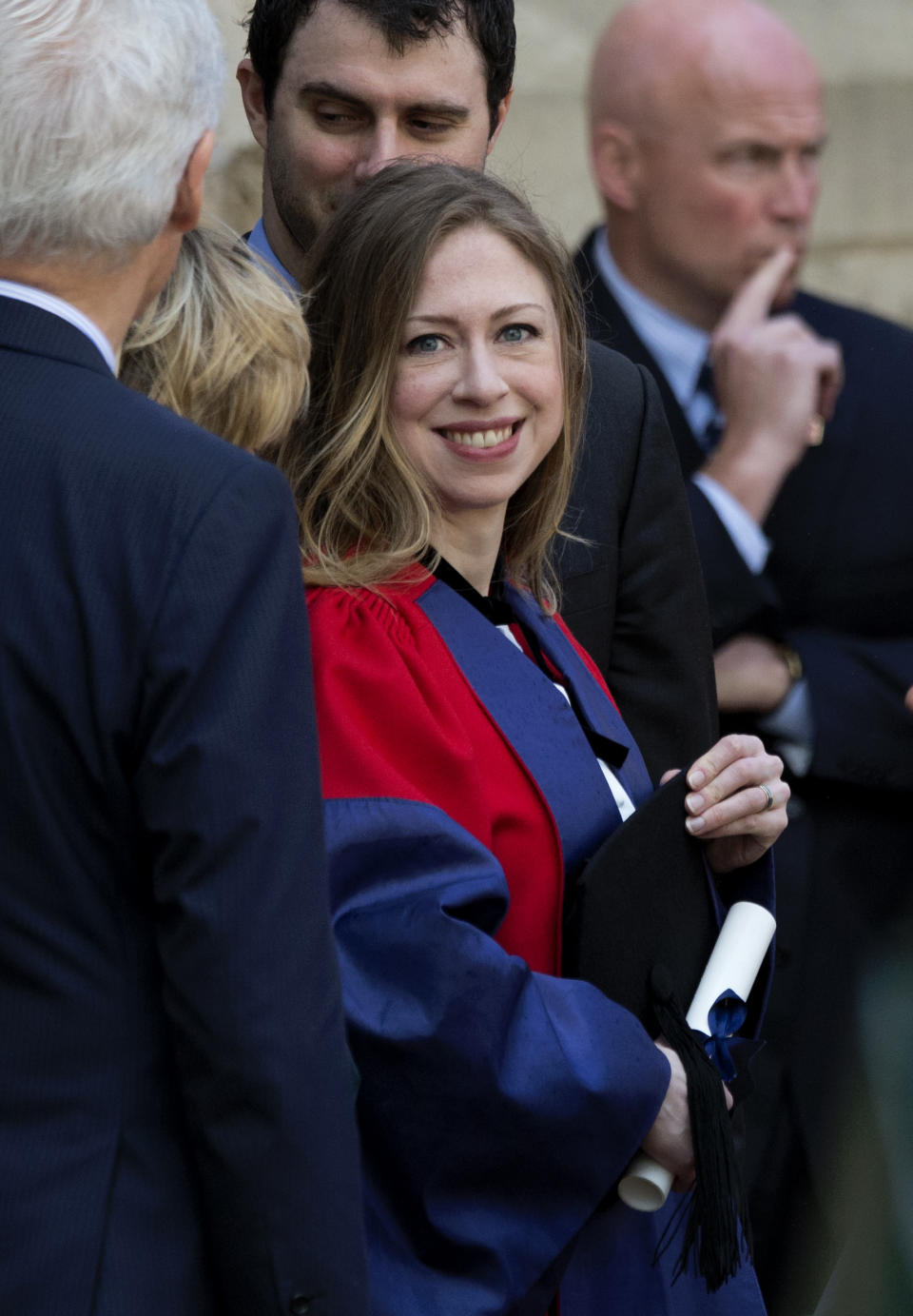 Chelsea Clinton, center, holds her certificate as she waits to pose for a formal photograph with her husband Marc Mezvinsky, center top, and her parents former U.S. President Bill Clinton, left, and former Secretary of State Hillary Rodham Clinton, second left obscured, after they attended Chelsea's Oxford University graduation ceremony at the Sheldonian Theatre in Oxford, England, Saturday, May 10, 2014. Chelsea Clinton received her doctorate degree in international relations on Saturday from the prestigious British university. Her father was a Rhodes scholar at Oxford from 1968 to 1970. The graduation ceremony comes as her mother is considering a potential 2016 presidential campaign. (AP Photo/Matt Dunham)