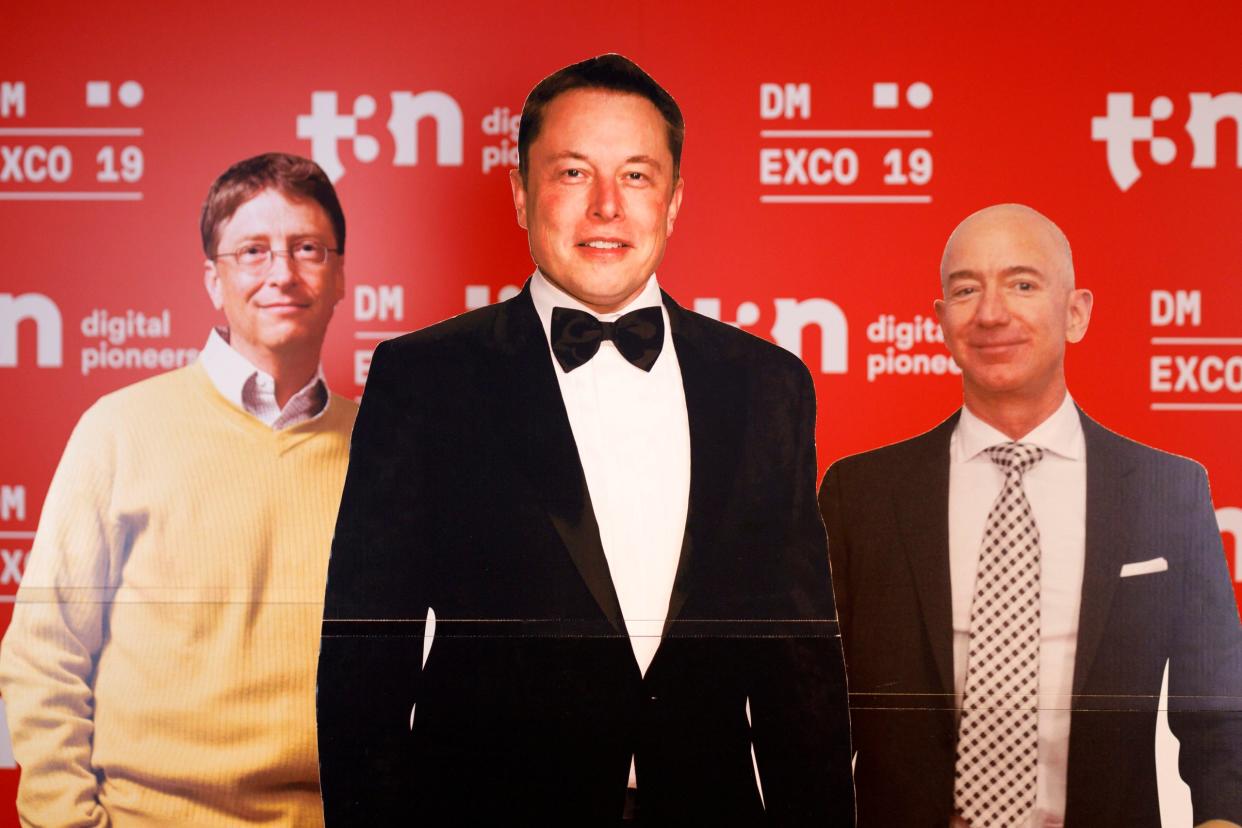 Pappaufsteller von Bill Gates, Elon Musk und Jeff Bezos stehen auf einer Fachmesse für digitales Marketing und Werbung in Köln. Die Männer gehören zu den reichsten Menschen der Welt.