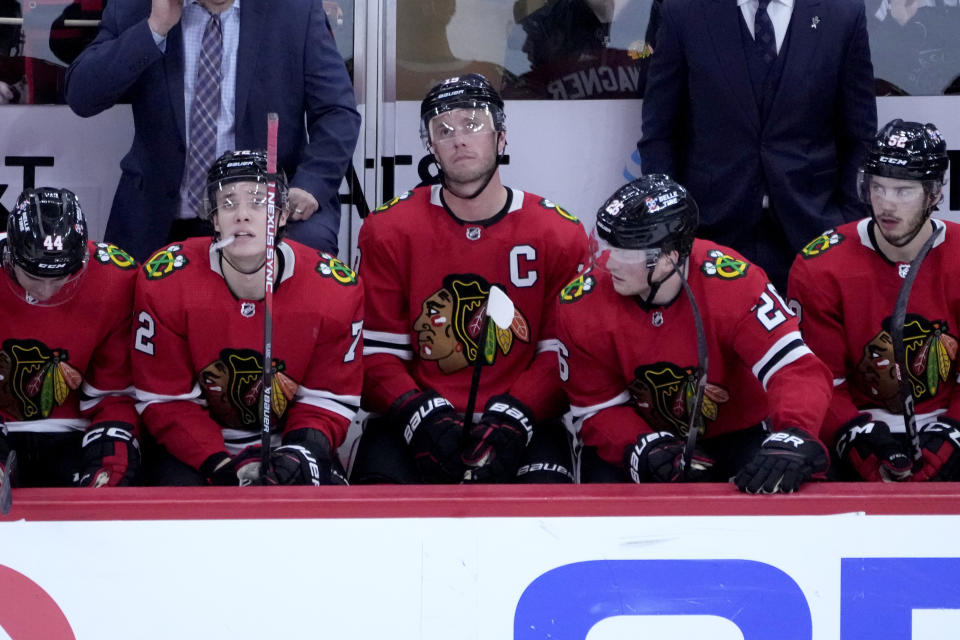 Chicago Blackhawks' Jonathan Toews, center, sits on the bench during the second period of the team's NHL hockey game against the New Jersey Devils on Saturday, April 1, 2023, in Chicago. Toews returned from a two-month medical leave of absence. (AP Photo/Charles Rex Arbogast)