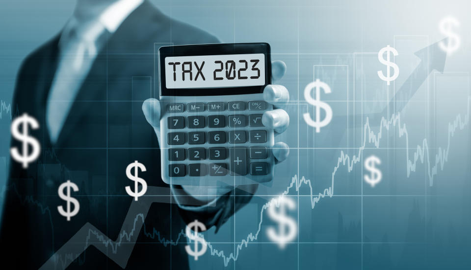 Tax 2023 on calculator. Business and tax concept .Businessman hold and show Calculator with word tax 2023. settlement income and property tax.�