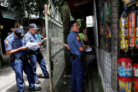 Policemen knock door to door and interview residents during a drug testing operation in Payatas, Quezon City, Metro Manila, Philippines August 23, 2017. REUTERS/Dondi Tawatao