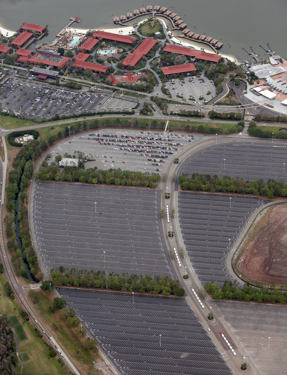 The nearly empty parking lot of Disney's Magic Kingdom theme park after it closed in an effort to combat the spread of coronavirus disease (COVID-19), in an aerial view in Orlando, Florida, U.S. March 16, 2020. At top is Disney's Polynesian Village Resort.  REUTERS/Gregg Newton