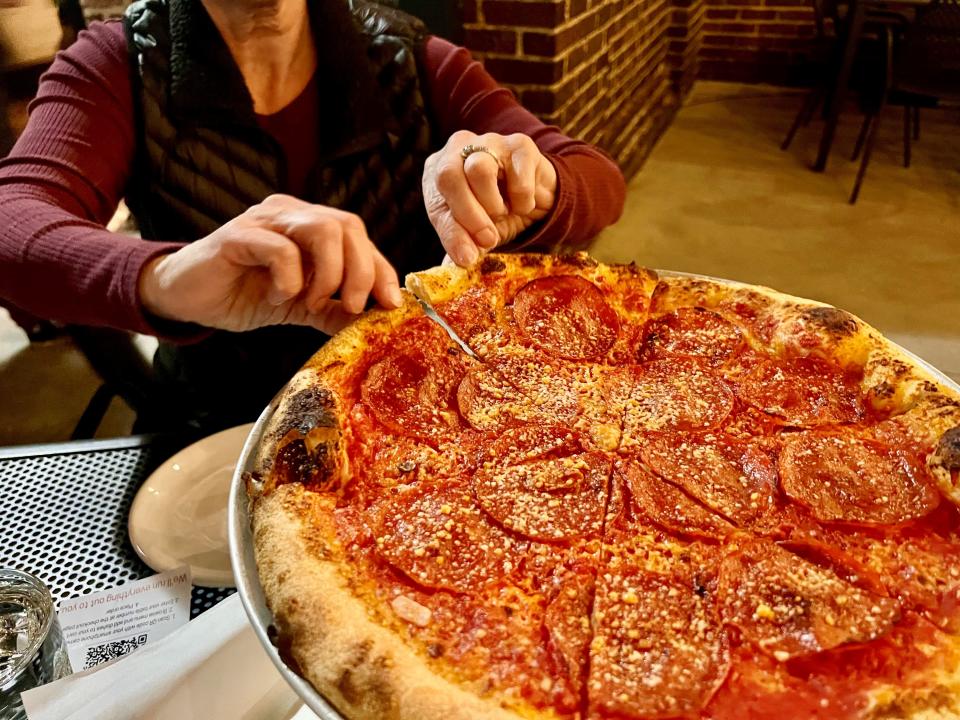 Nancy Gill gets a slice of pepperoni at Nicky's Coal Fired in West Nashville on Nov. 10, 2022