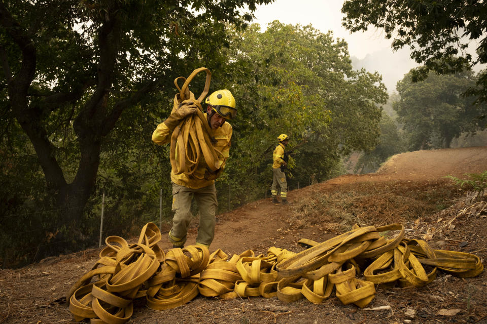 Emergency crews and firefighters are working to extinguish the fire advancing through the forest in La Orotava in Tenerife, Canary Islands, Spain on Saturday, Aug. 19, 2023. Firefighters have battled through the night to try to bring under control the worst wildfire in decades on the Spanish Canary Island of Tenerife, a major tourist destination. The fire in the north of the island started Tuesday night and has forced the evacuation or confinement of nearly 8,000 people. Regional officials say Friday's efforts will be crucial in containing the fire. (AP Photo/Arturo Rodriguez)