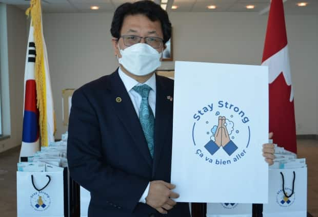 Consul General Lee Yun-je stands in front of bags of medical masks before they are sent out from the South Korean consulate in Montreal. (Submitted by Consulate General of the Republic of Korea in Montreal - image credit)