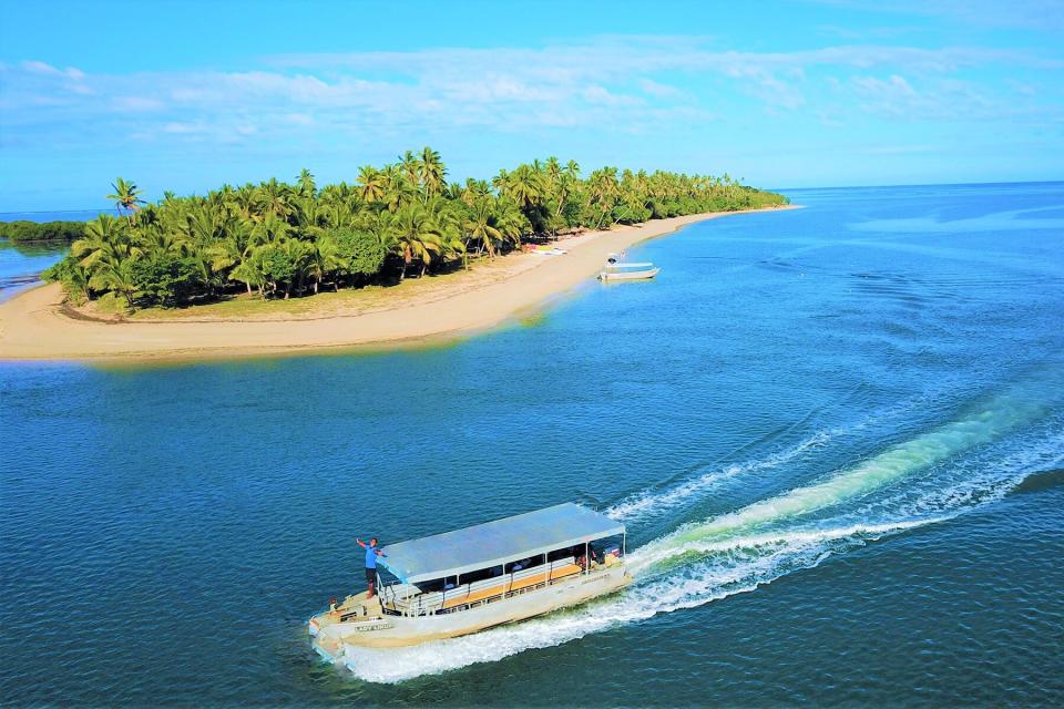 A transport boat sailing past Likuri Island Resort in Fiji