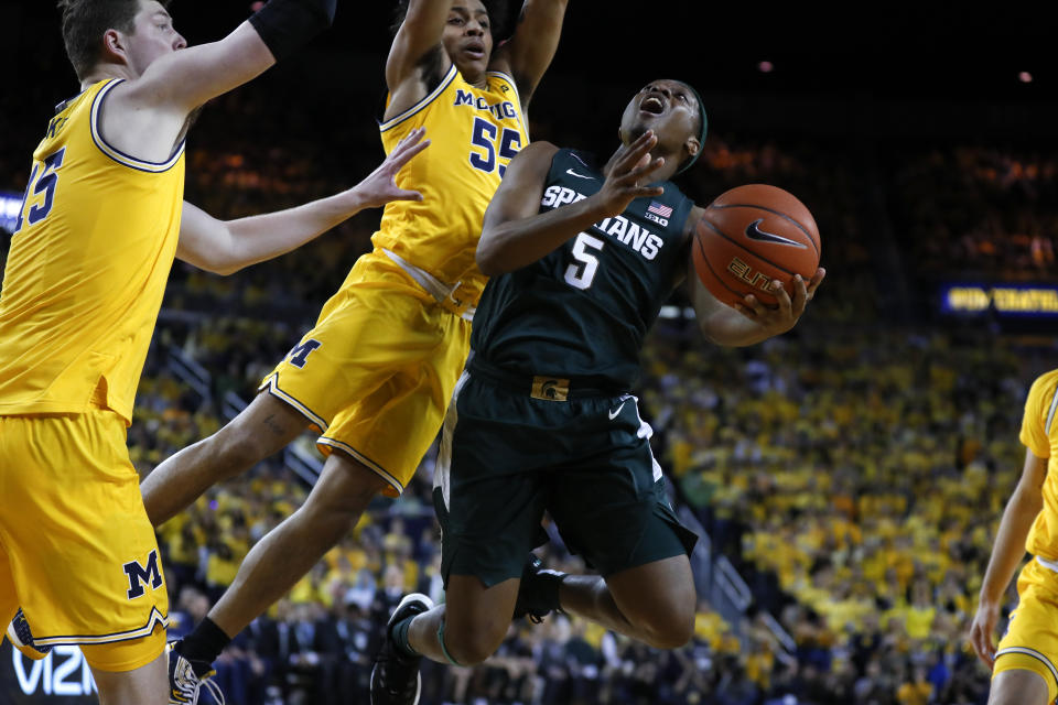 Michigan State guard Cassius Winston (5) drives on Michigan guard Eli Brooks (55) in the first half of an NCAA college basketball game in Ann Arbor, Mich., Saturday, Feb. 8, 2020. (AP Photo/Paul Sancya)