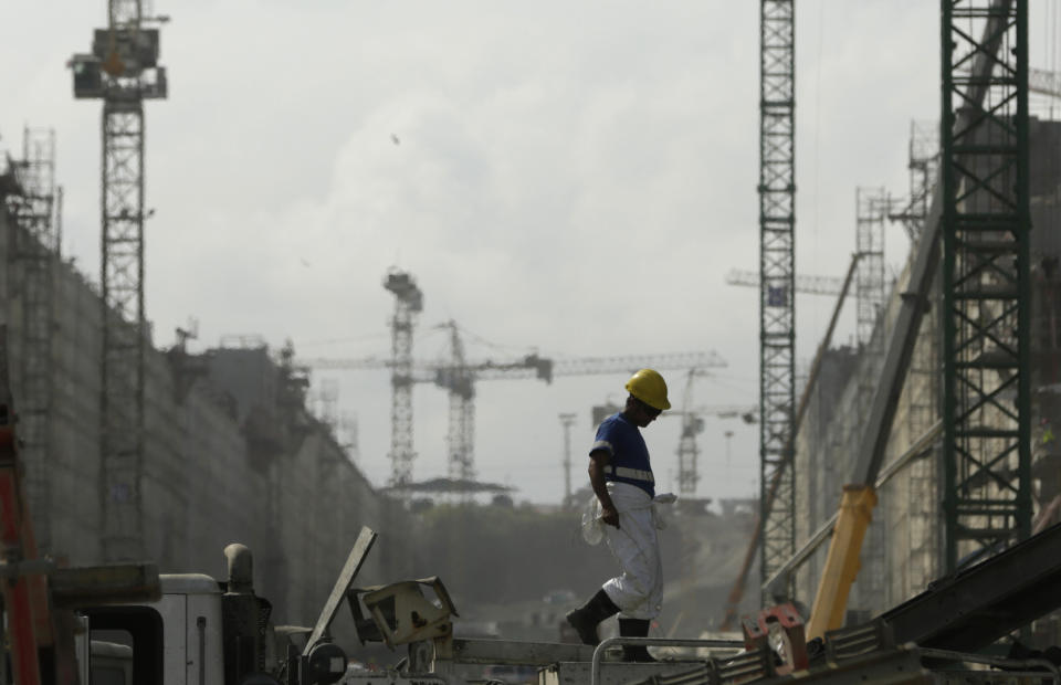 In this Jan. 15, 2014 photo, a construction worker walks at the site of the Panama Canal's Atlantic expansion project in Gatun, north of Panama City. The Spanish-led consortium hired to handle the biggest part of the canal expansion says it will halt work by Monday, Jan. 20 if the canal authority doesn’t come up with the funds to cover cost overruns, while the authority insists the consortium live up to the terms of the original contract. (AP Photo/Arnulfo Franco)