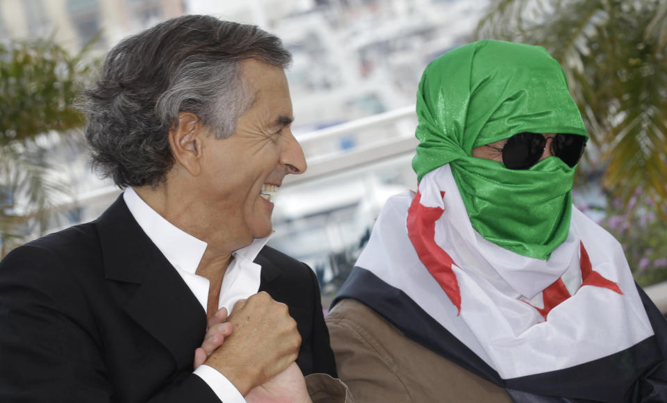 Director Bernard-Henry Levy, left, and an unidentified person wearing a Syrian flag pose during a photo call for The Oath of Tobruk at the 65th international film festival, in Cannes, southern France, Friday, May 25, 2012. (AP Photo/Lionel Cironneau)