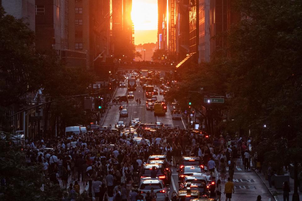 The sun sets over Manhattan on 42nd street during Manhattanhenge in New York, July 11, 2022.