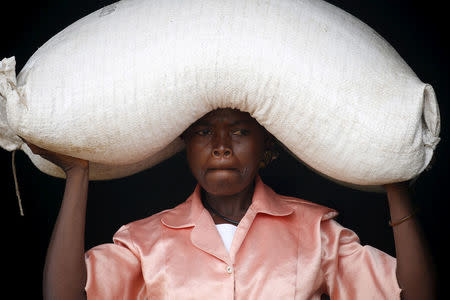A woman carries food aid distributed by the United Nations World Food Progamme (WFP) in Mzumazi village near the capital Lilongwe, Malawi February 3, 2016. REUTERS/Mike Hutchings/File Photo