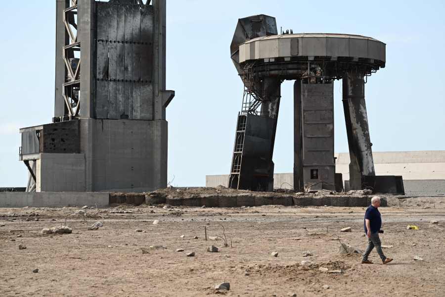 A man walks through a debris field at the launch pad on April 22, 2023, after the SpaceX Starship lifted off on April 20 for a flight test from Starbase in Boca Chica, Texas. (Photo by PATRICK T. FALLON/AFP via Getty Images)