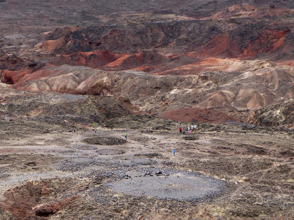 View from the high volcanic ridge overlooking Lothagam North Pillar site. In the foreground, the 30m platform contains the mortuary cavity, and is ringed by boulders, with a linear arrangement of pillars on its east side: PNAS