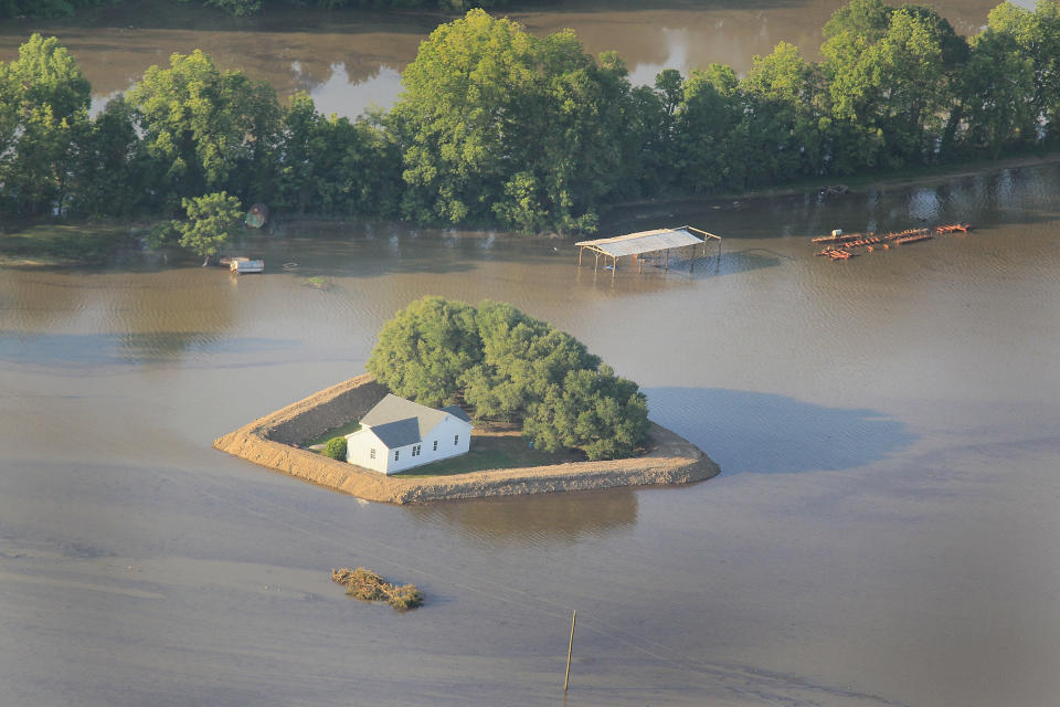 VICKSBURG, MS - MAY 18: A levee protects a home surrounded by floodwater from the Yazoo River May 18, 2011 near Vicksburg, Mississippi. The flooded Mississippi River is forcing the Yazoo River to top its banks where the two meet near Vicksburg causing towns and farms upstream on the Yazoo to flood. The Mississippi River at Vicksburg is expected to crest May 19. Heavy rains have left the ground saturated, rivers swollen, and have caused widespread flooding along the Mississippi River from Illinois to Louisiana. (Photo by Scott Olson/Getty Images)