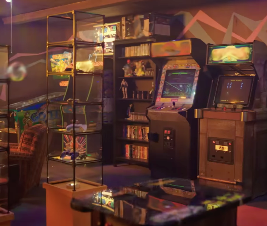 A collection of retro arcade games and cartridges in a tricked out game room from "1UP"