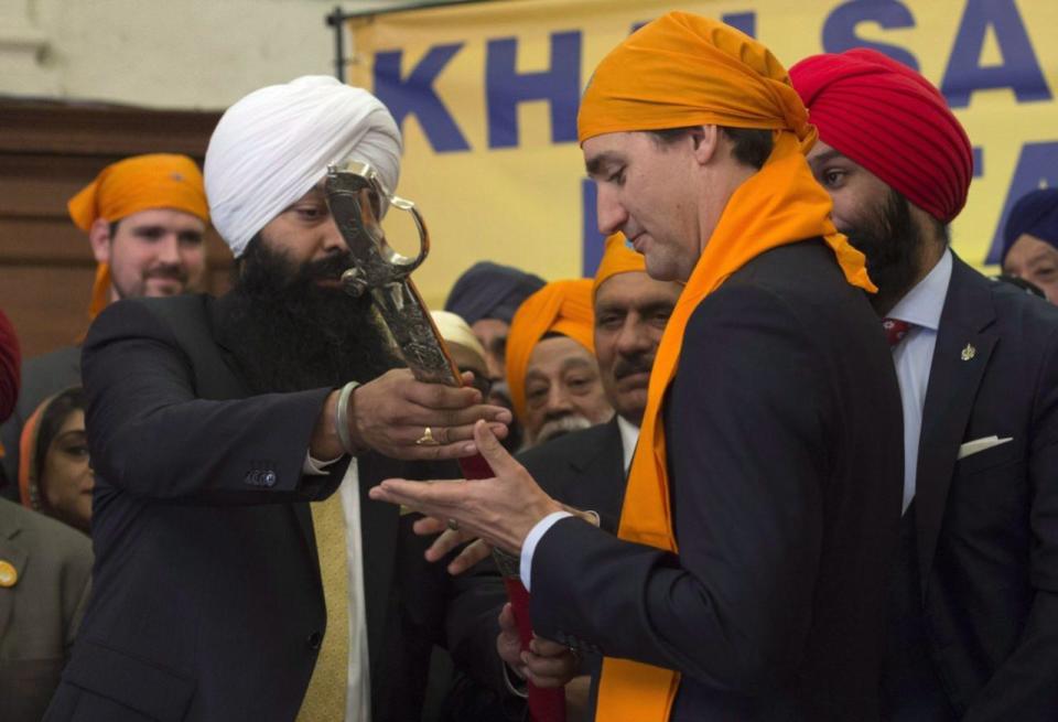 Surrounded by members of the Sikh Caucus Prime Minister Justin Trudeau is presented with a traditional sword during a Vaisakhi Celebration on Parliament Hill in Ottawa, Monday, April 11, 2016. THE CANADIAN PRESS/Adrian Wyld