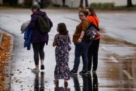 People walk in a parking lot near the scene of a shooting at the Boise Towne Square shopping mall in Boise, Idaho