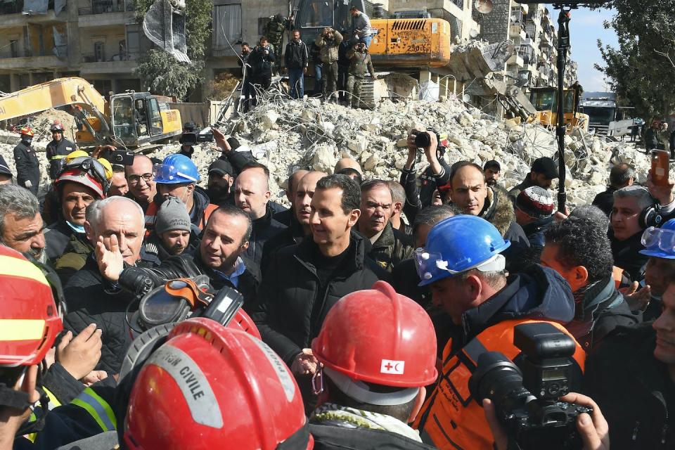 Syrian President Bashar Assad, center, on Feb. 10, 2023, visits neighborhoods hit by an earthquake in Aleppo. <a href="https://www.gettyimages.com/detail/news-photo/syrian-president-bashar-al-assad-visits-neighbourhoods-news-photo/1246979089?phrase=syria%20earthquake%20Bashar%20al-Assad&adppopup=true" rel="nofollow noopener" target="_blank" data-ylk="slk:AFP via Getty Images;elm:context_link;itc:0;sec:content-canvas" class="link ">AFP via Getty Images</a>