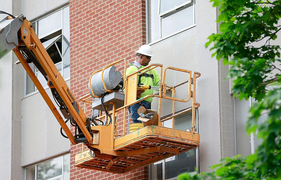 A worker is seen working on the exterior of Clayton Hall on Wednesday, May 25, 2022. Clayton Hall is being renovated by Ashland University this summer.