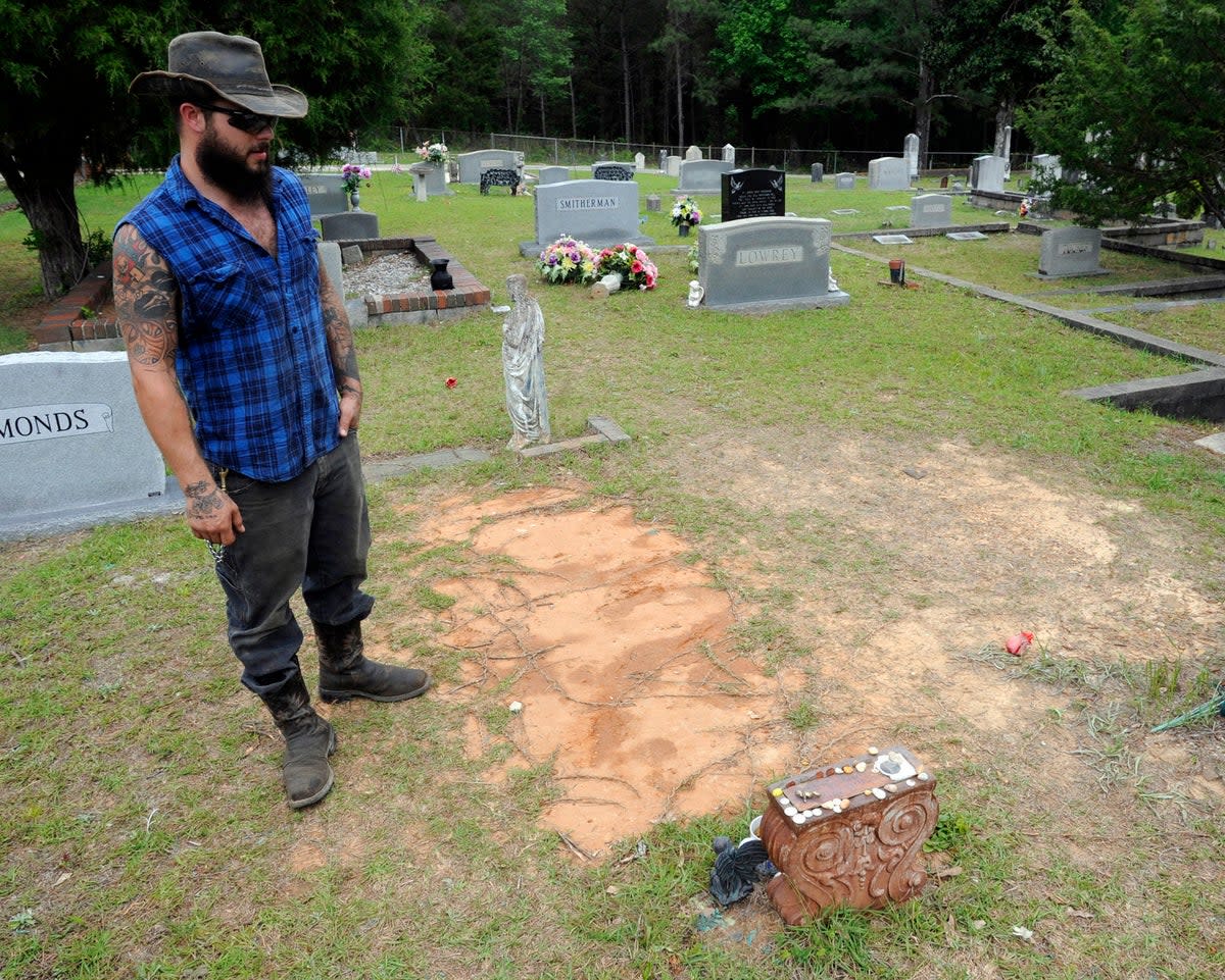 Tyler Goodson of the hit podcast S-Town stands at the grave in Green Pond, Ala., of his late friend John B. McLemore, who is also featured in the show, on May 3, 2017 (Copyright 2017 The Associated Press. All rights reserved.)