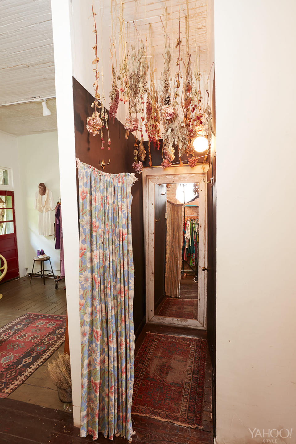 A vintage, floral-patterned textile hangs in the dressing room.