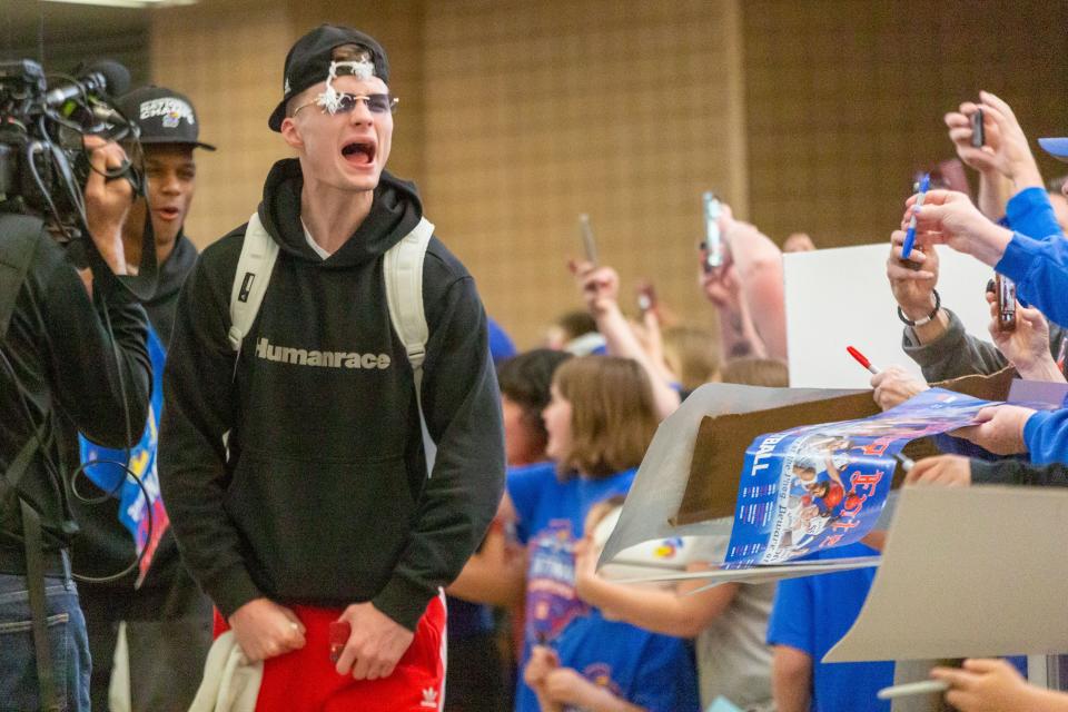 Kansas native Christian Braun yells for the enthusiastic crowd of Kansas Jayhawks fans as the team returns from winning the NCAA men's basketball championship inside the terminal at Topeka Regional Airport at Forbes Field on Tuesday, April 2, 2022,