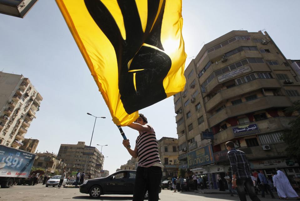 A supporter of Egypt's ousted President Mursi waves banner of Rabaa sign during a march in Shubra street in Cairo