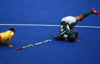 Spain's Pablo Amat (L) and Pakistan's Muhammad Irfan fall during their men's Group A hockey match at the London 2012 Olympic Games at the Riverbank Arena on the Olympic Park in London July 30, 2012.
