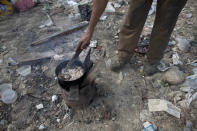 <p>A man cooks chicken skin he found at the dump in Puerto Cabello, Venezuela, the port city where the majority of Venezuela’s imported food arrives, Nov. 1, 2016. When imported food goes bad at the port, the military tries to get rid of it quietly by burying it at dumps like this one. Residents say they’ve been able to recover oats, sunflower seeds, and pig feed dumped by the military. (Ariana Cubillos/AP) </p>