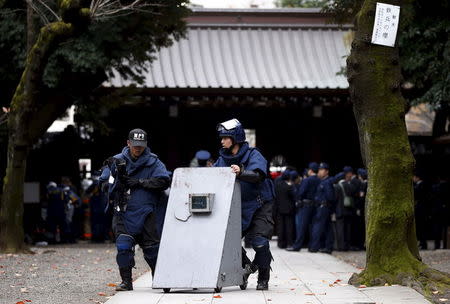 Members of a police bomb disposal squad move a blast protection device near the site of an explosion at the Yasukuni shrine in Tokyo, Japan, November 23, 2015. REUTERS/Toru Hanai