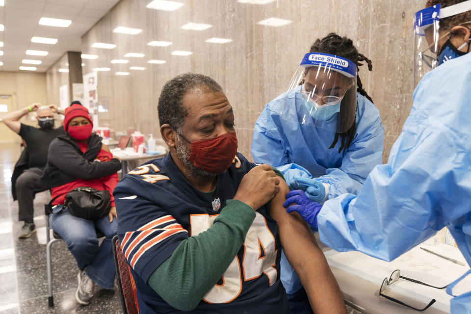 In this Thursday, Feb. 11, 2021, photo Peter Thomas, 58, of Washington, receives his second dose of the COVID-19 vaccine at a clinic at Howard University, in Washington. (AP Photo/Jacquelyn Martin)