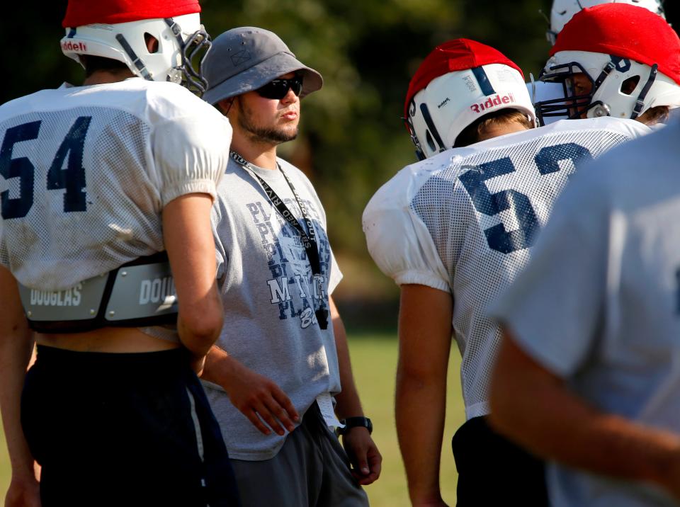 Minco football coach Brock Wardlaw talks with players during practice on Sept. 29, 2015.