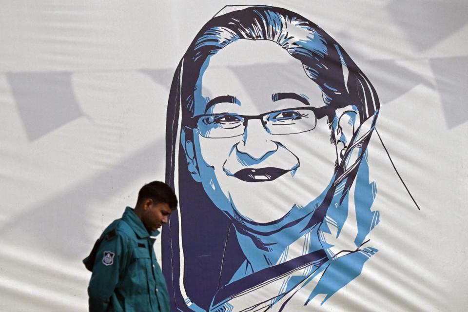 A policeman walks past a portrait of Bangladesh's Prime Minister Sheikh Hasina, in Dhaka (AFP via Getty Images)