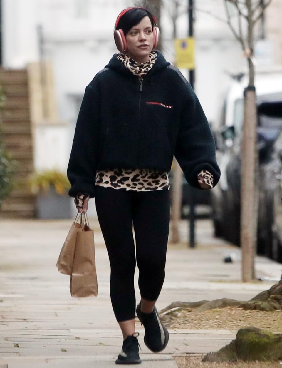 <p>Lily Allen totes some goodies while listening to tunes in London on Monday morning. </p>
